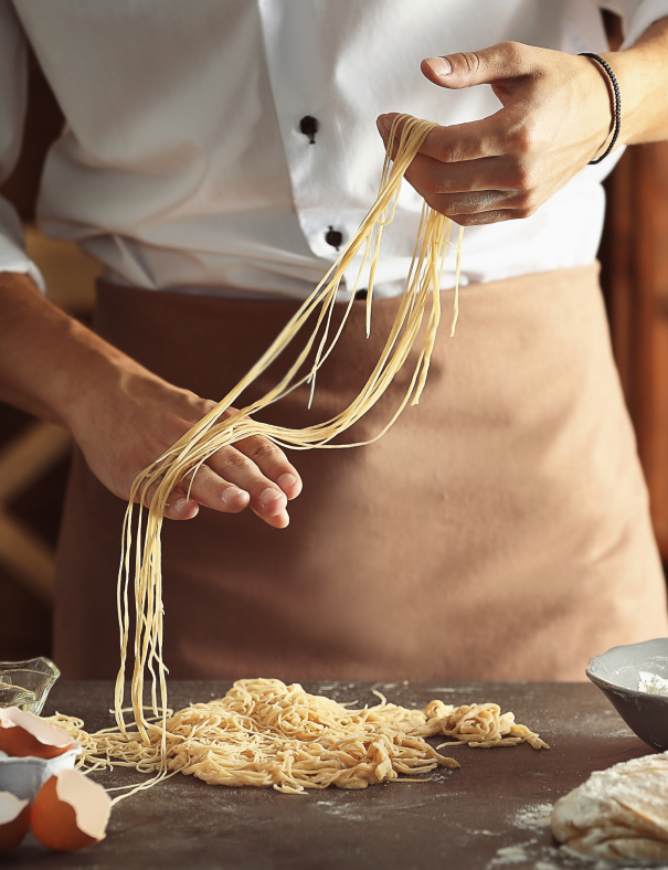 man-preparing-pasta-kitchen-table-close-up-view 1